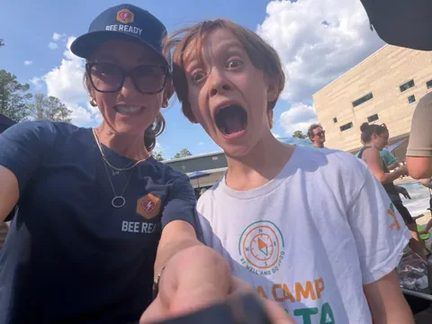 A BeeReady volunteer and a happy young camper sharing a laugh at the meet.
